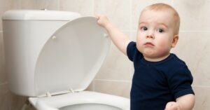 small child standing next to toilet