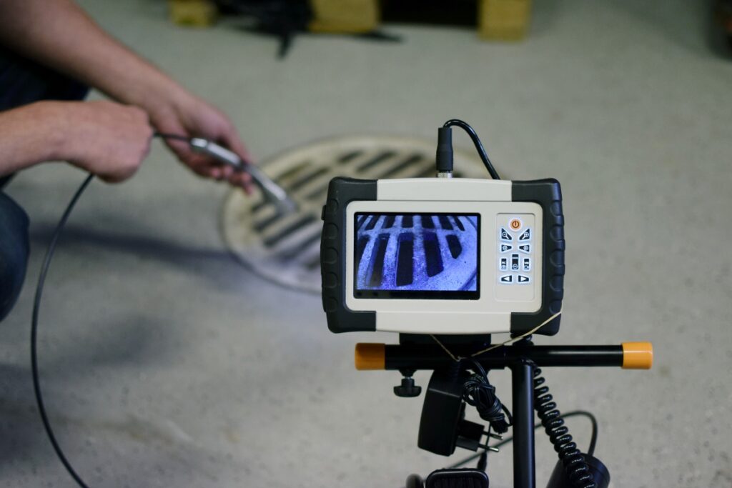 man using camera so see in pipe