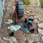 plumber feeding hose into pipe