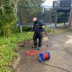 plumber feeding hose into pipe