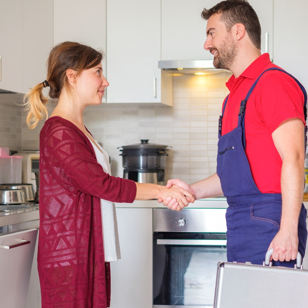 woman shaking hands with plumber