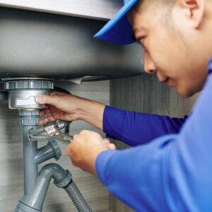 Man inspects under-sink drain