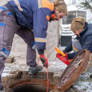 Two men perform sewer camera inspection