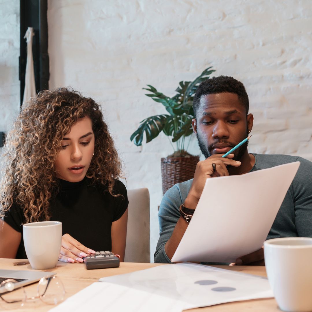 a couple looking at paperwork with a calculator